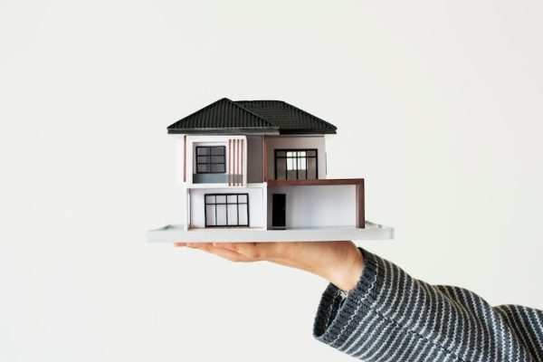 hand-presenting-model-house-home-loan-campaign_53876-104970